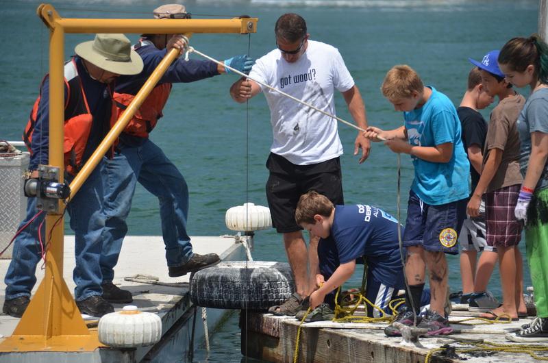 Ocean Defender volunteers Steve and Kellin and team hauling up tire