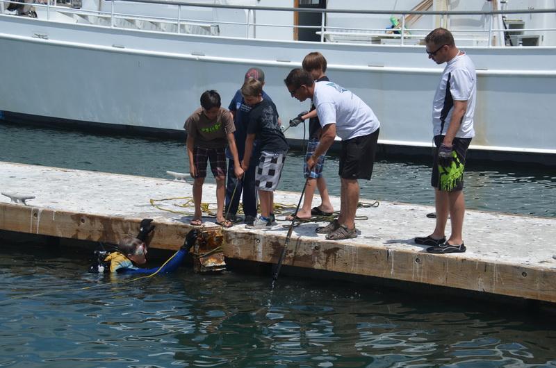 Ocean Defender Dive Crew Tom Weisel handing up debris to boys