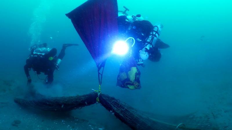 ODA volunteer SCUBA divers Jeff Larsen and Kim Cardenas ridding ocean of abandonded squid net.