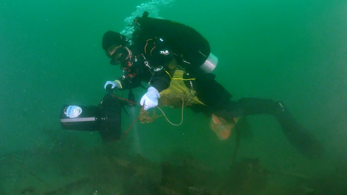 ODA diver with scooter searches for debris