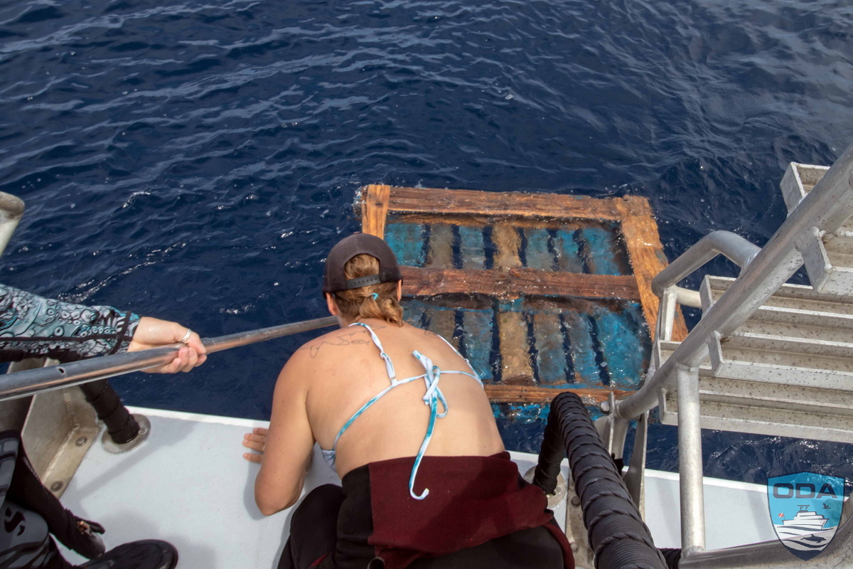 Crew retrieving floating pallet debris