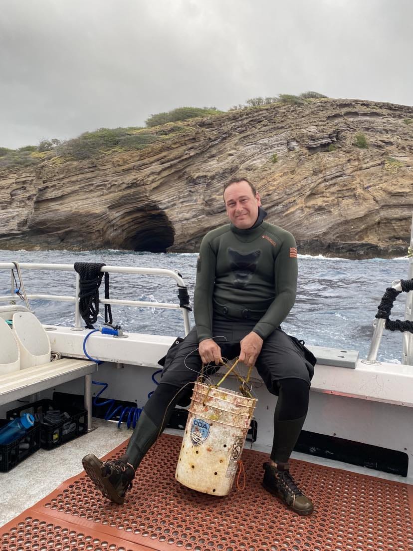Crewmember Ed with Lost Bucket; see Sea Cave behind