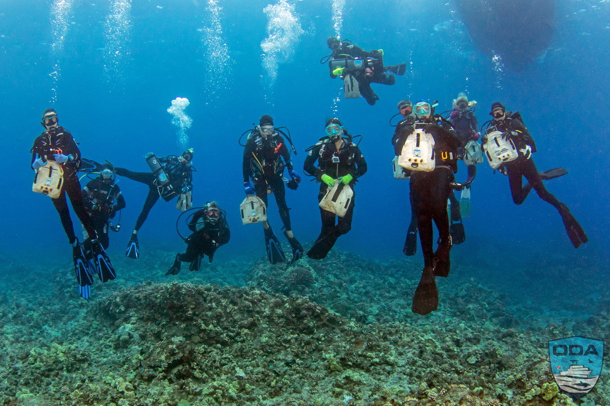 The entire dive team with their collection bags full of marine debris.